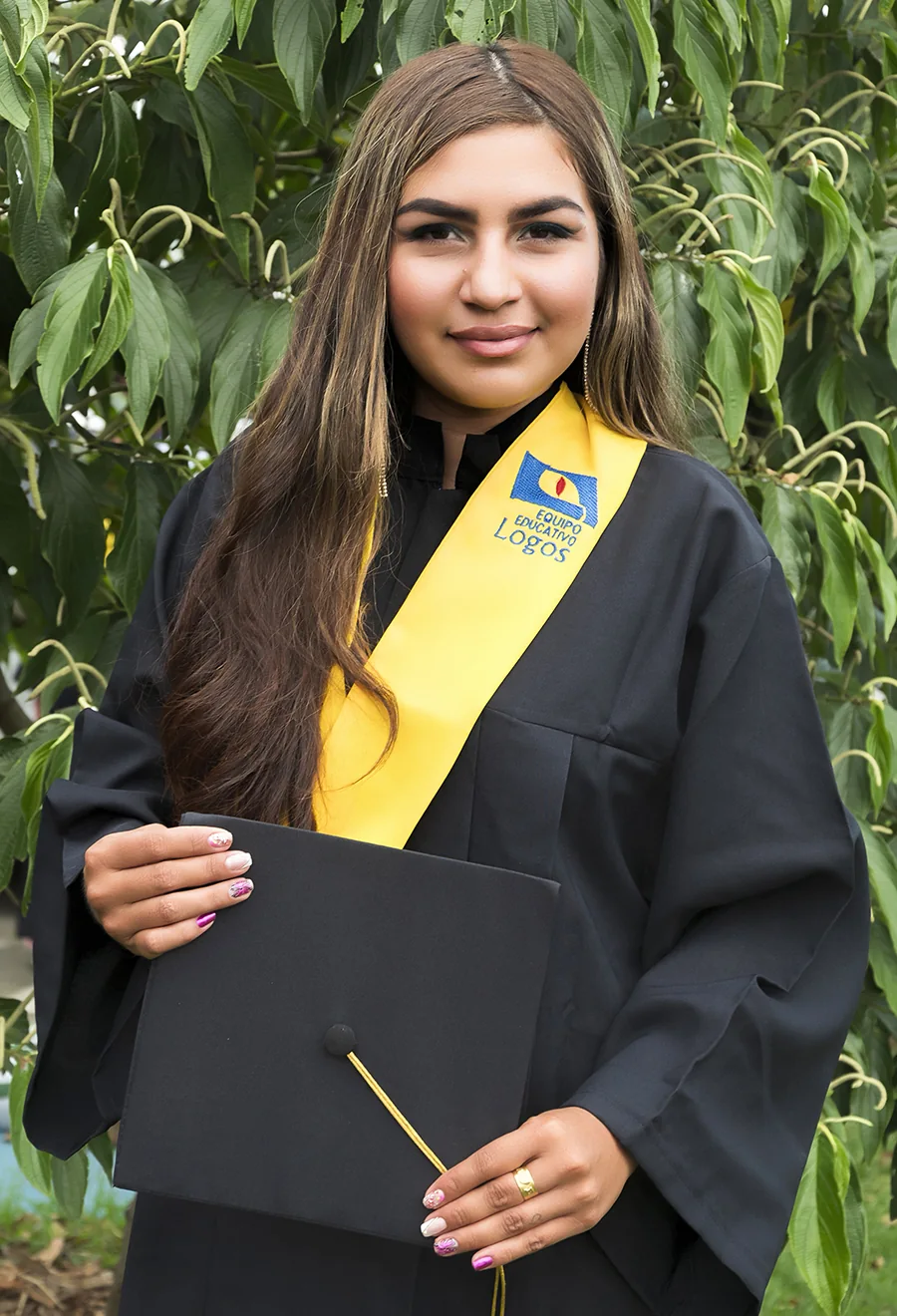 Graduada de Instituto LOGOS con birrete y diploma